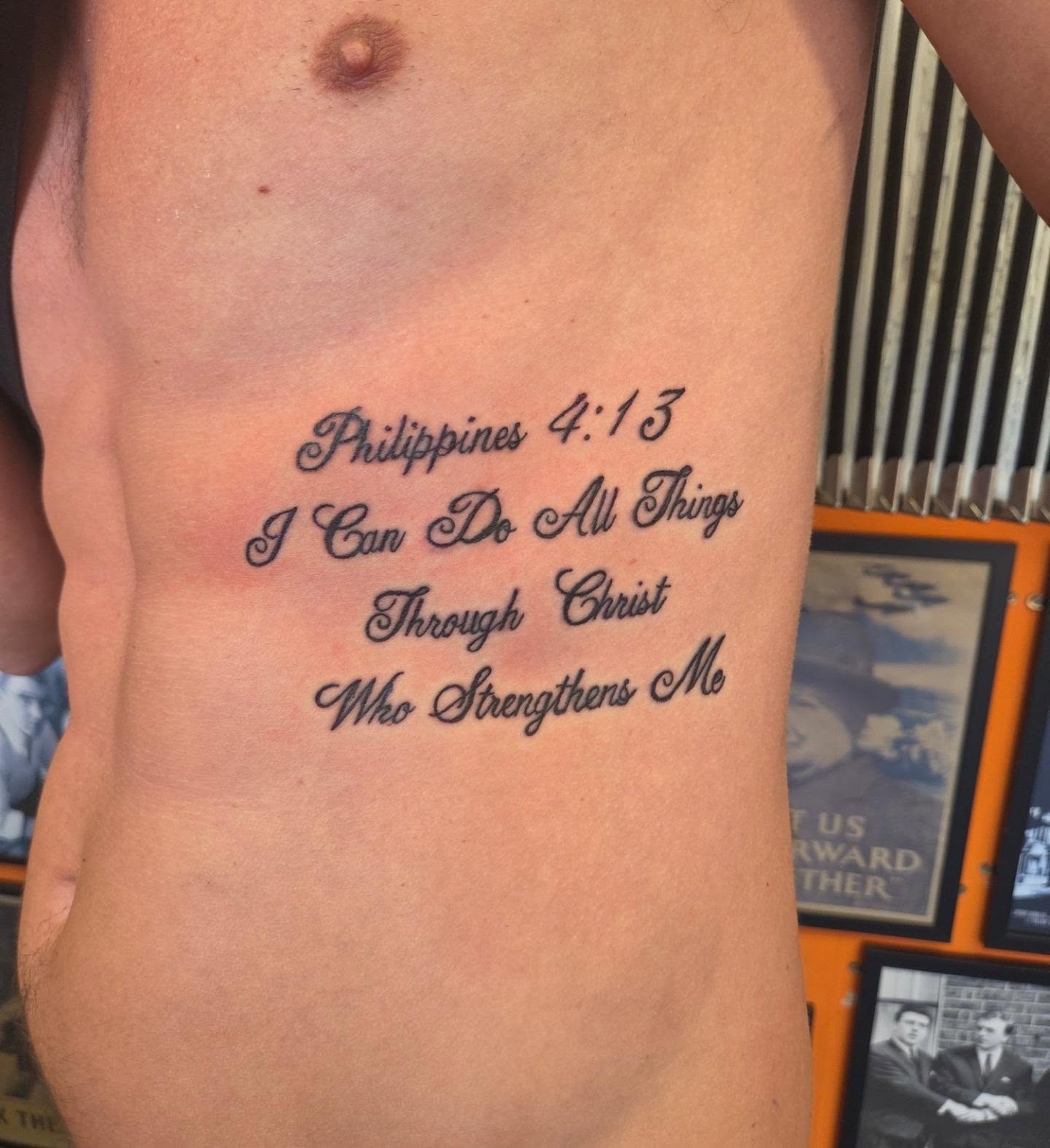 Philippians scripture lettering tattoo in black script on the side of the torso