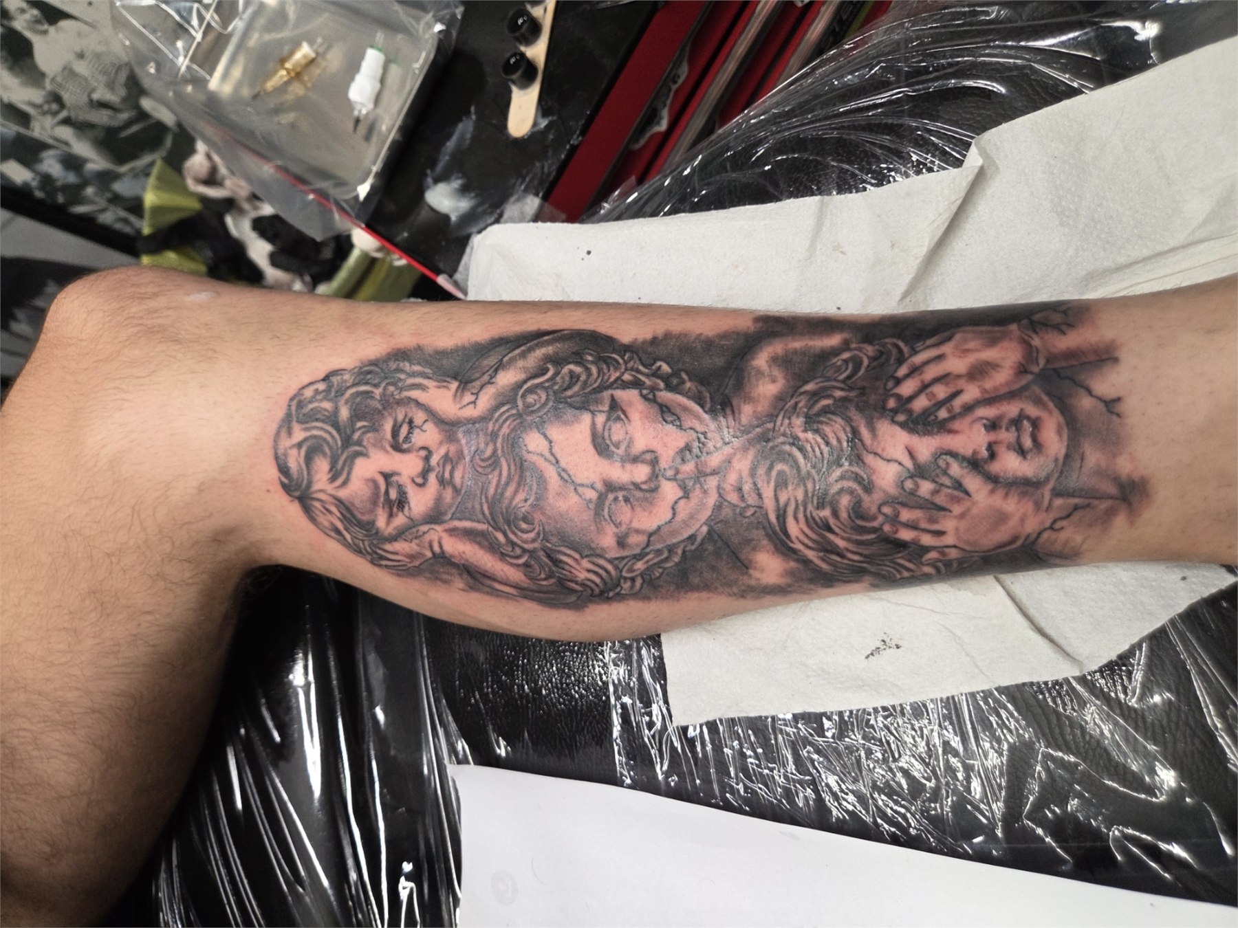 Detailed black and grey figures forearm tattoo