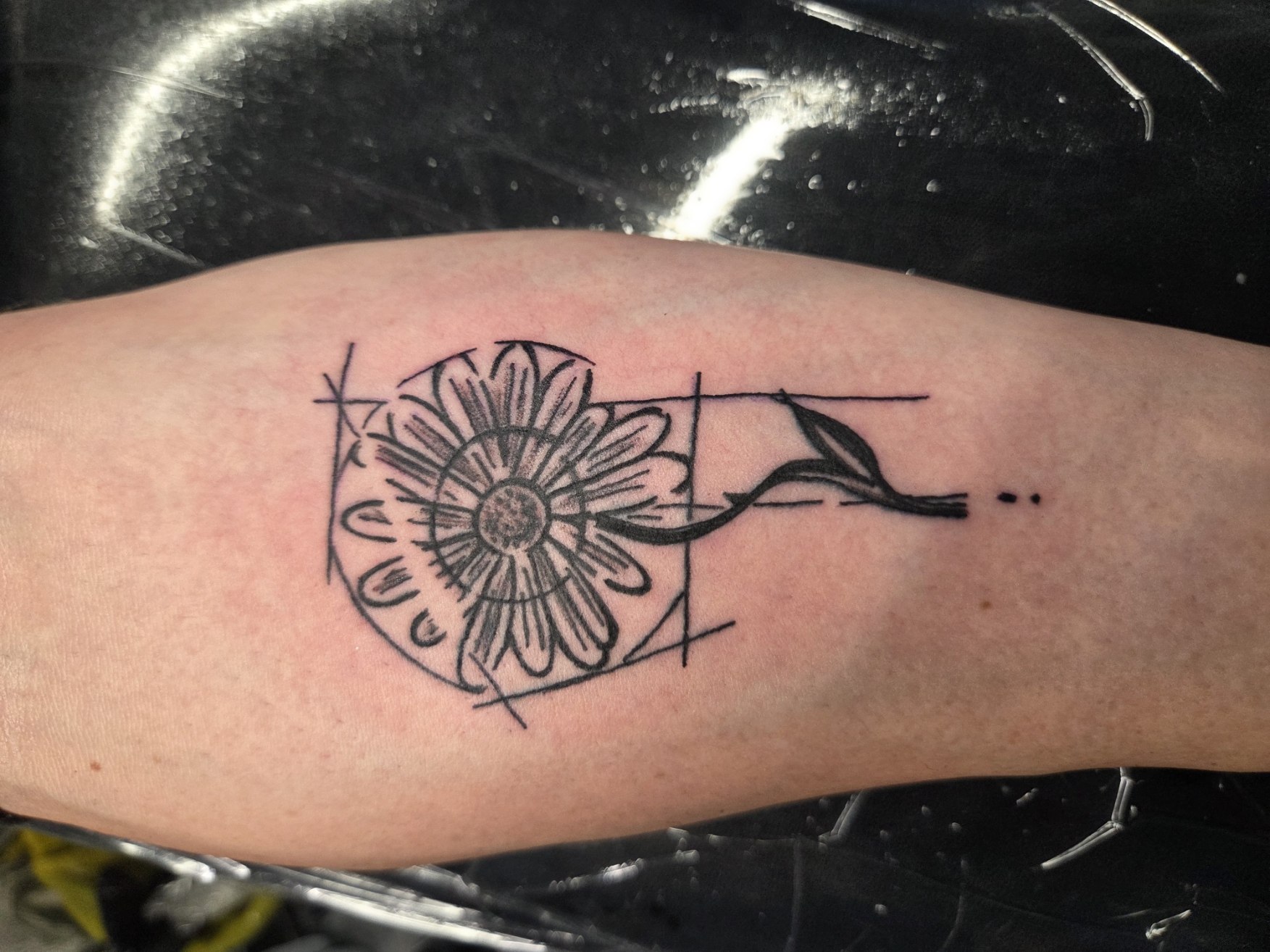 Fine-line flower and circular geometric tattoo