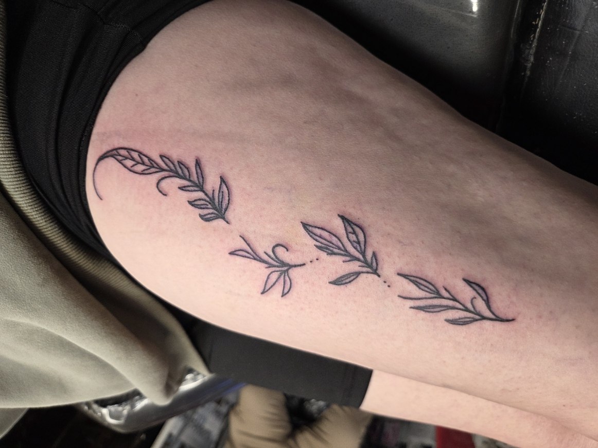 Delicate fine-line botanical leaf tattoo