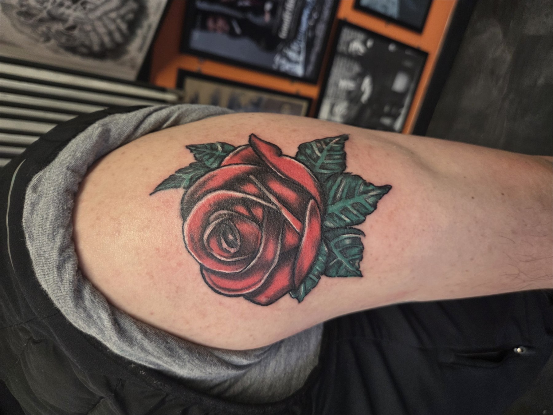 Rich red rose and green leaves tattoo