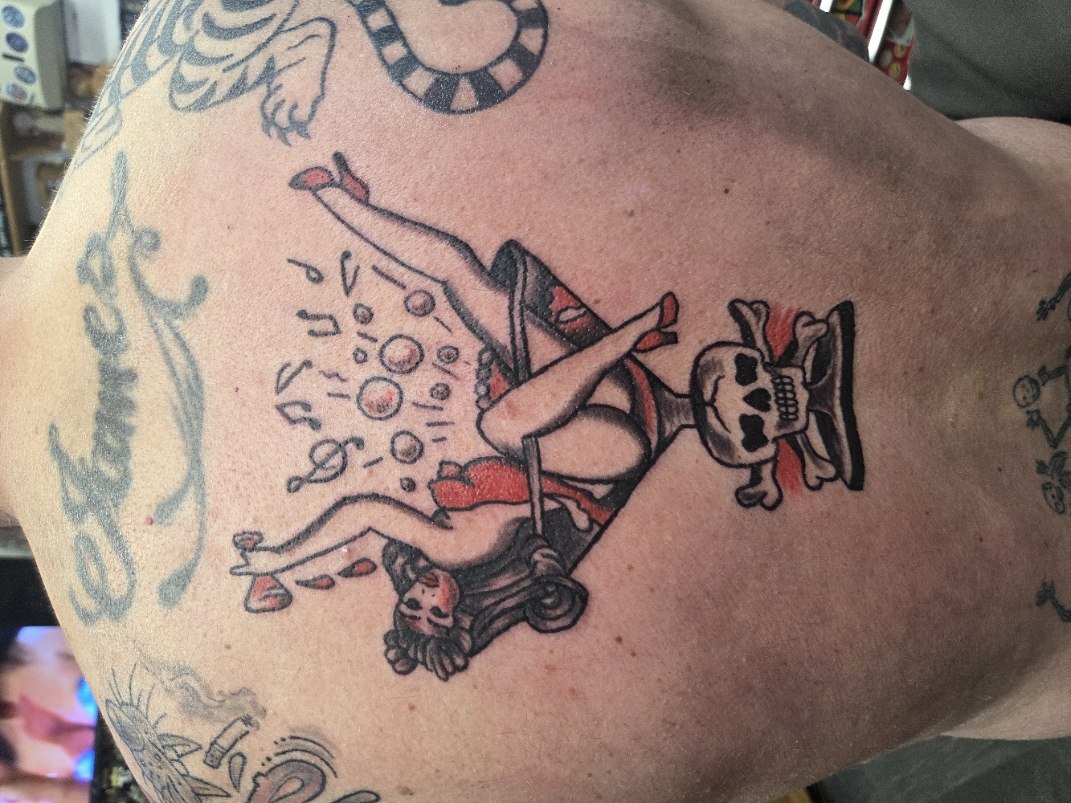 Playful skeleton pin-up tattoo with red details